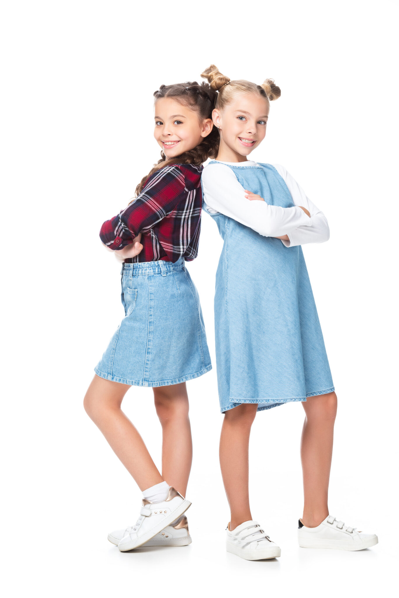 adorable schoolchildren standing back to back with crossed arms isolated on white